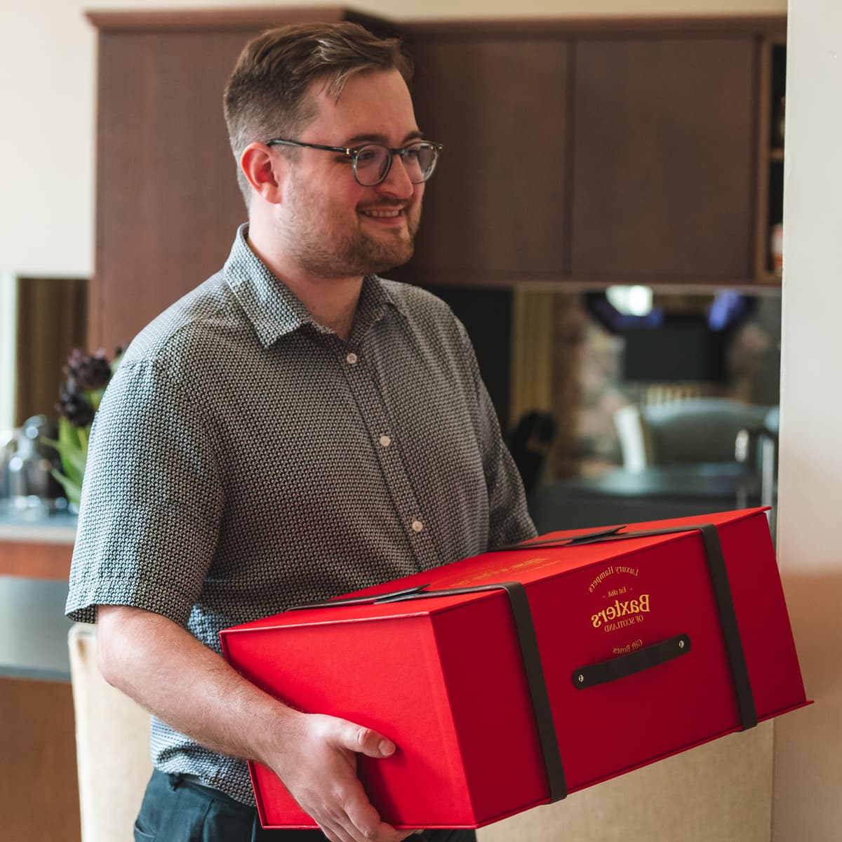 A man carrying a Baxters hamper