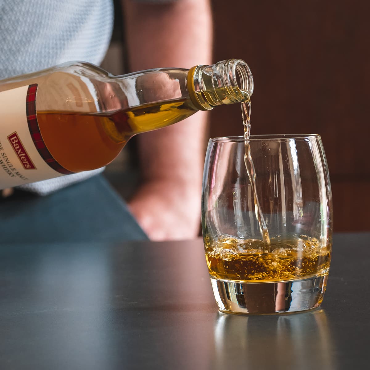 A bottle of Baxters whisky being poured into a glass